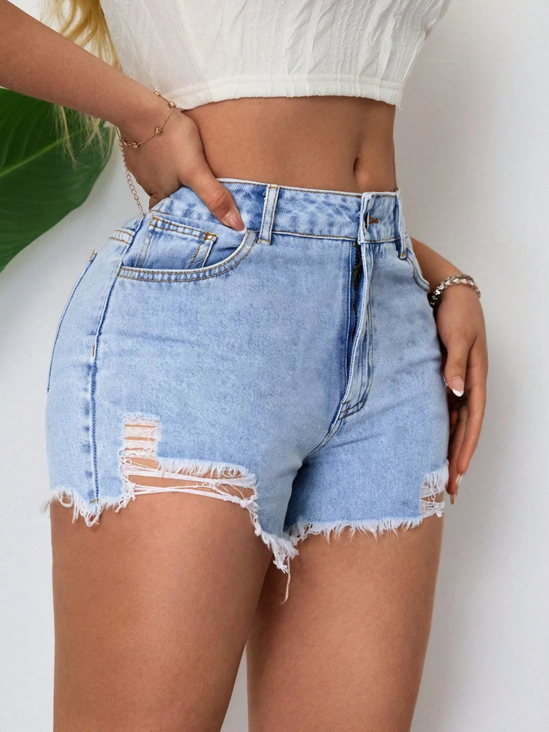 High-rise distressed denim shorts with raw hem