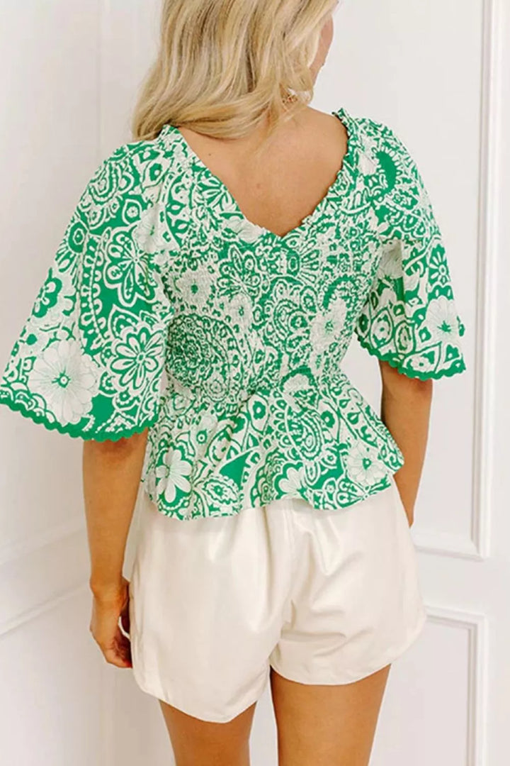 Smocked V-neck floral peplum blouse with flutter sleeves