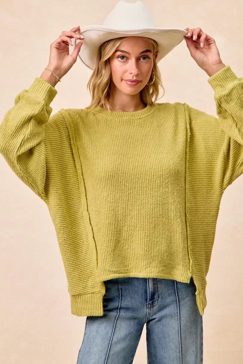 Ribbed boucle knit sweater with exposed seams and uneven hem