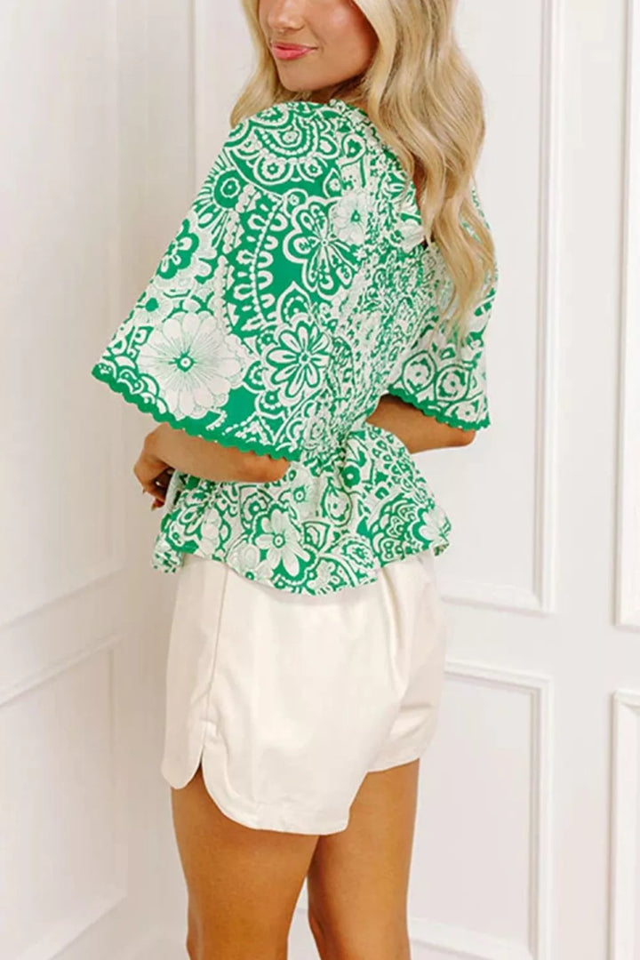 Smocked V-neck floral peplum blouse with flutter sleeves