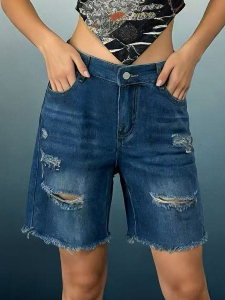 Distressed mid-thigh denim shorts with raw frayed hem