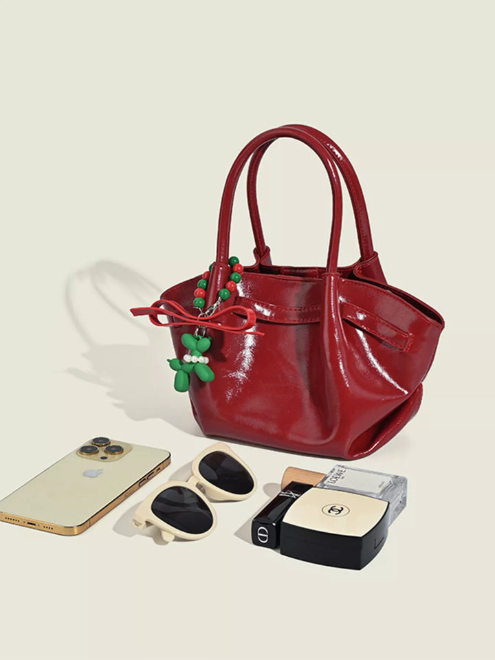 Glossy slouchy top handle crossbody bag with beaded charm