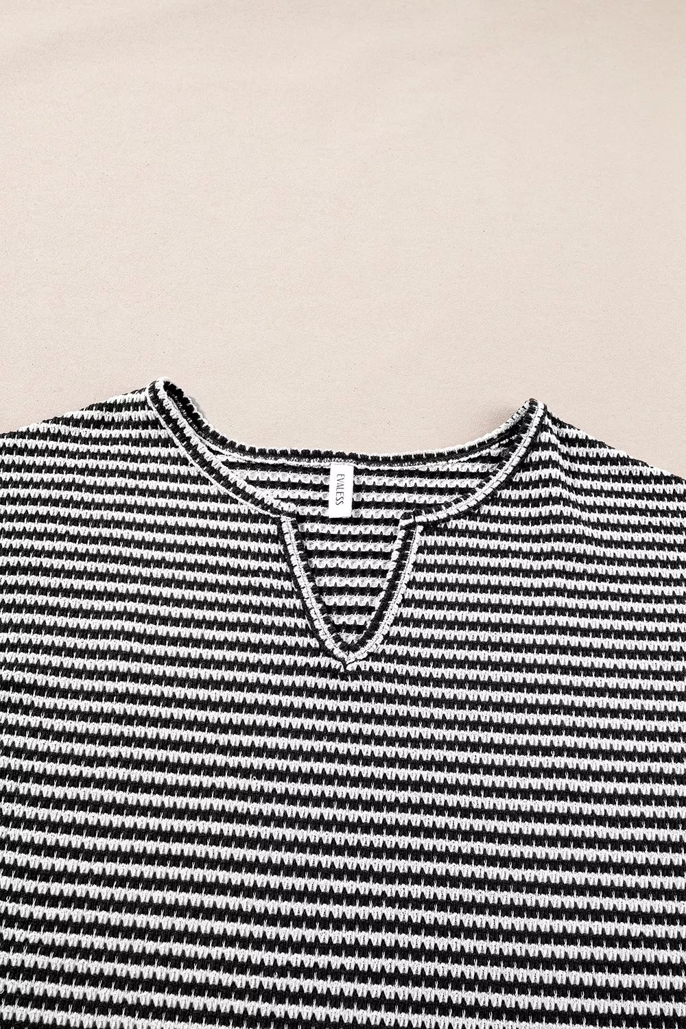 Striped textured knit top with notched V-neck and cuffed sleeves