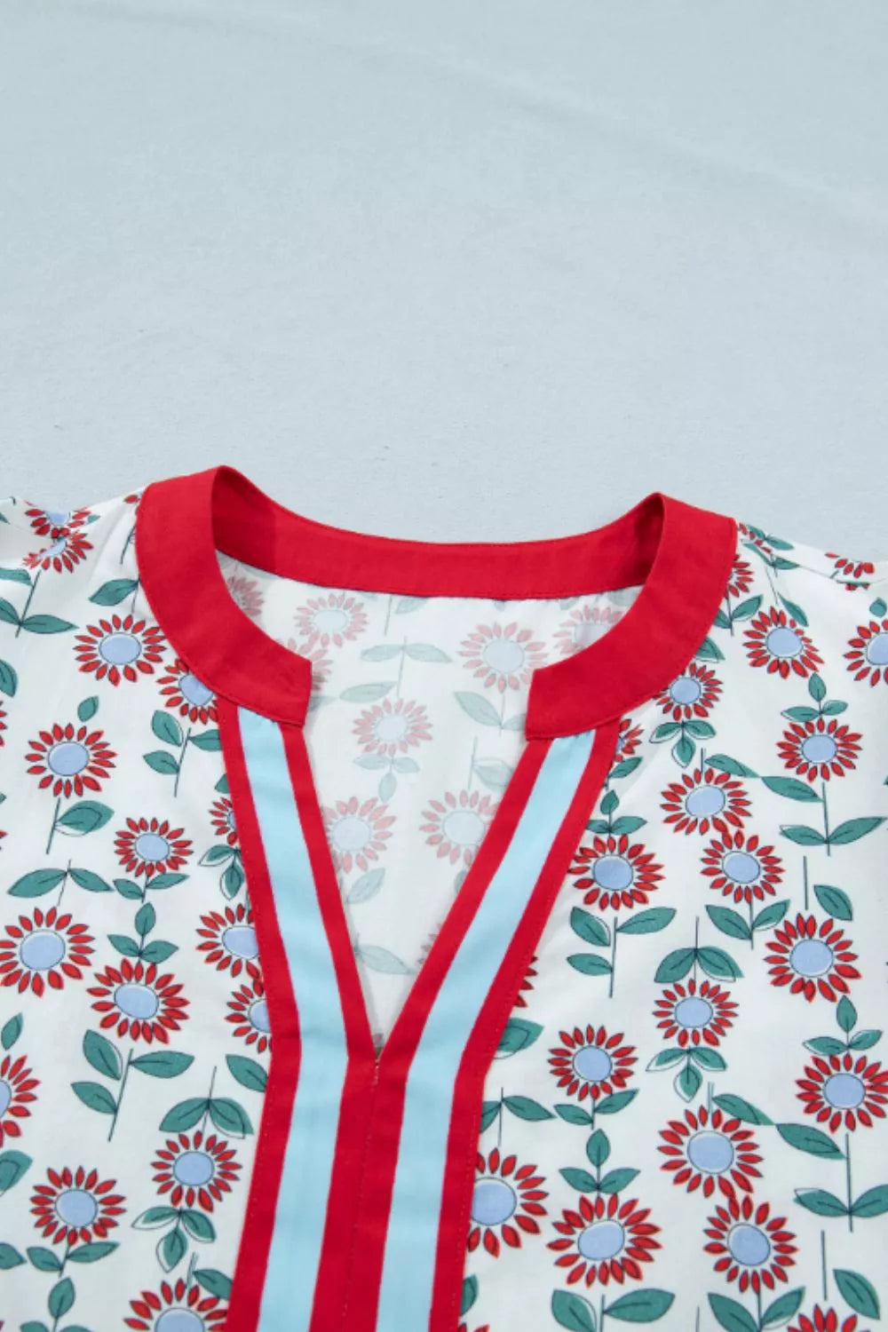 Floral babydoll blouse with ruffle cap sleeves and striped V-neck
