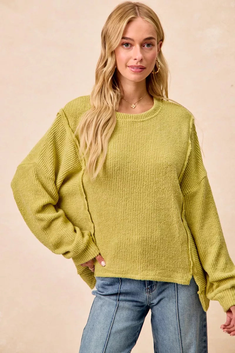 Ribbed boucle knit sweater with exposed seams and uneven hem