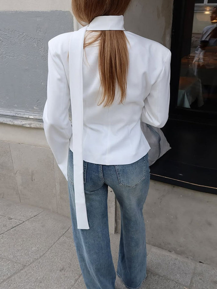 Fitted button-up blazer with tie-neck scarf and structured shoulders