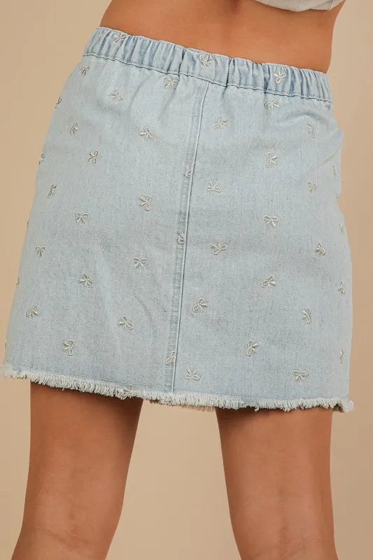 Bow-embroidered denim mini skirt with raw hem