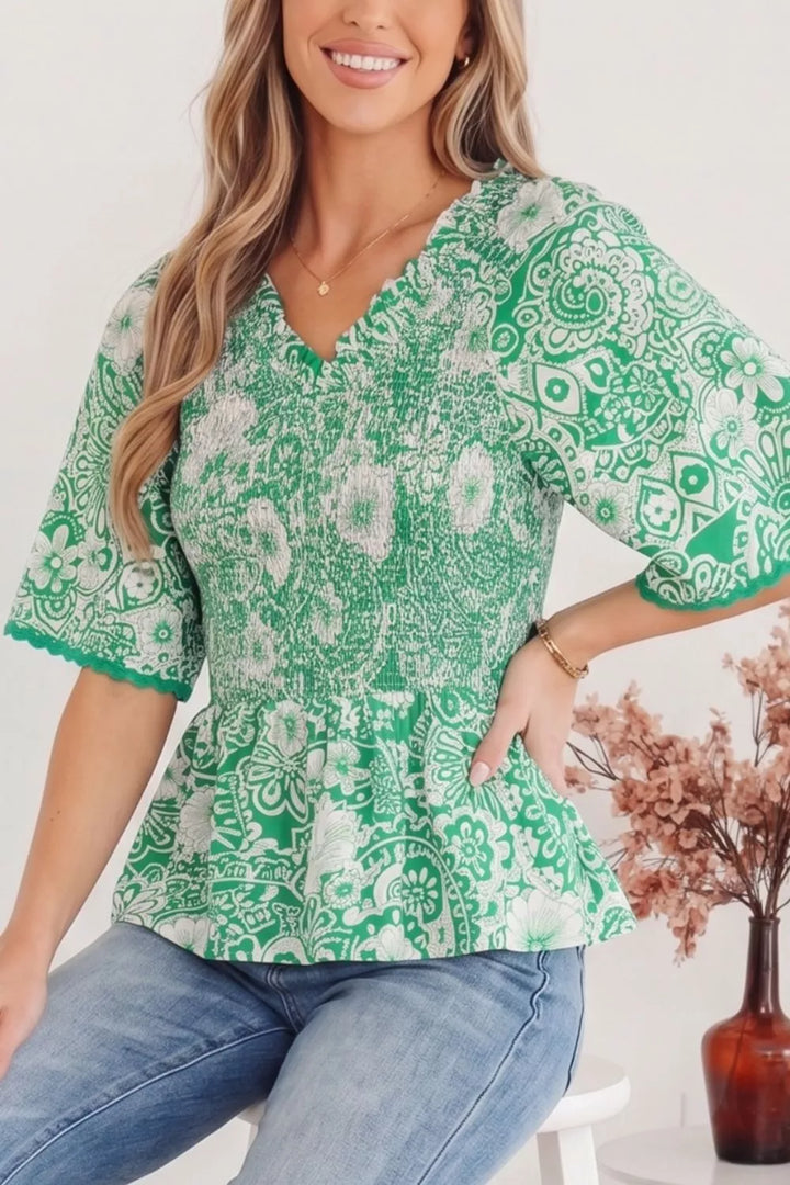 Smocked V-neck floral peplum blouse with flutter sleeves