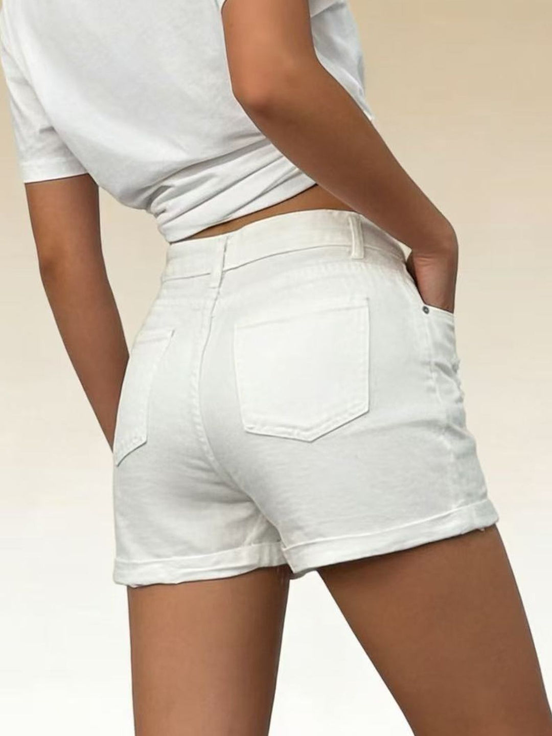 High-rise distressed denim shorts with button fly and rolled hem