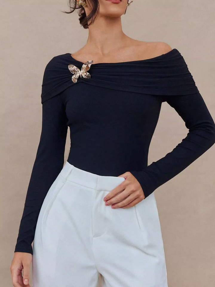 Black Off-shoulder long sleeve top with gold butterfly brooch