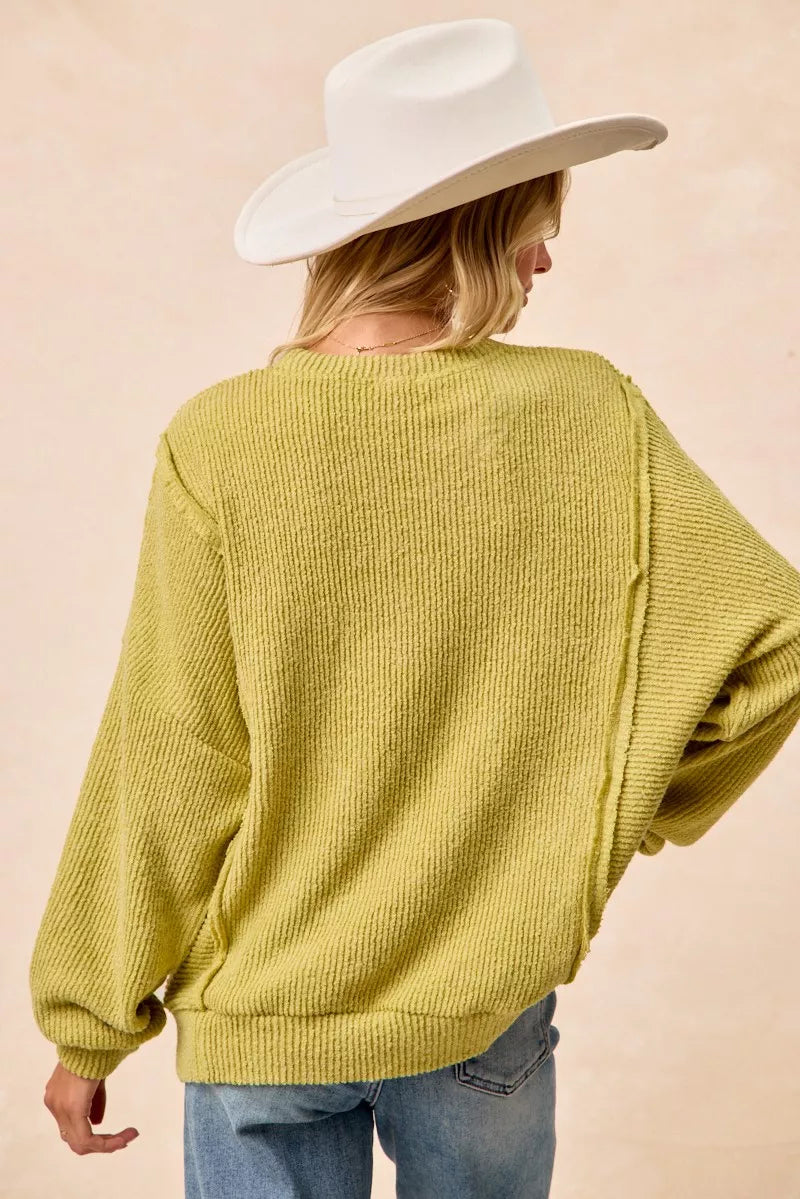 Ribbed boucle knit sweater with exposed seams and uneven hem