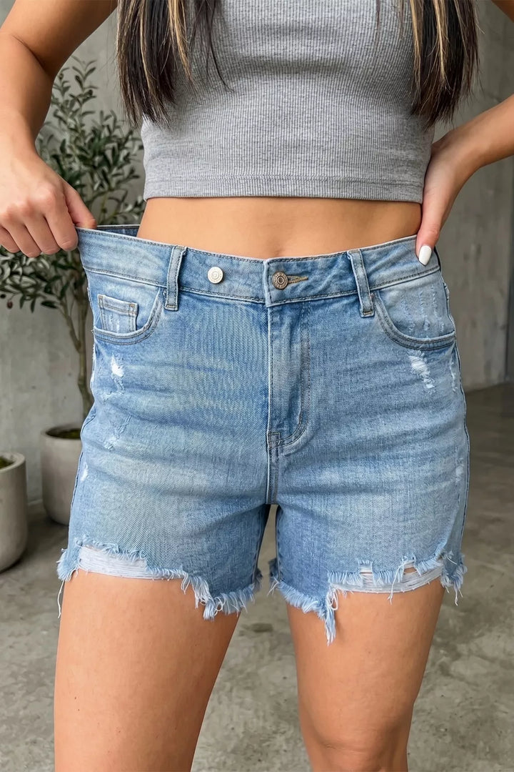 Distressed mid-rise denim shorts with asymmetric raw hem