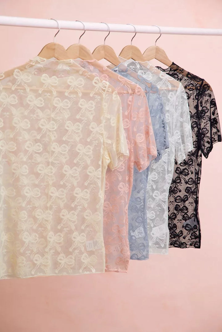 Sheer mesh mock-neck top with allover bow pattern