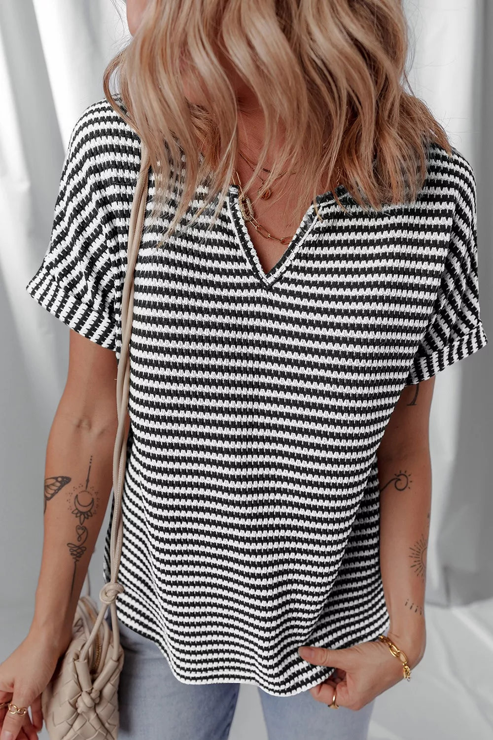 Striped textured knit top with notched V-neck and cuffed sleeves