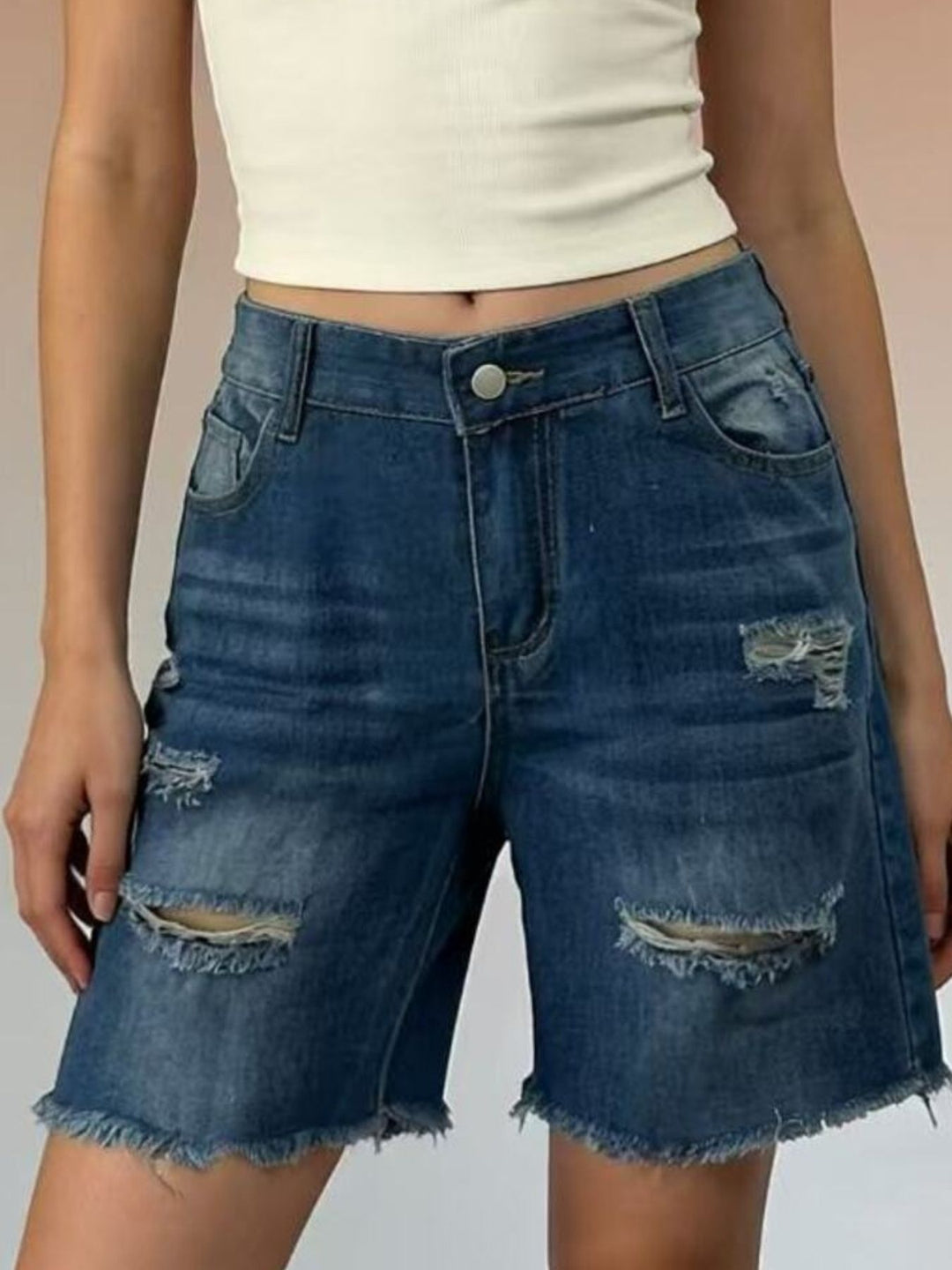 Distressed mid-thigh denim shorts with raw frayed hem