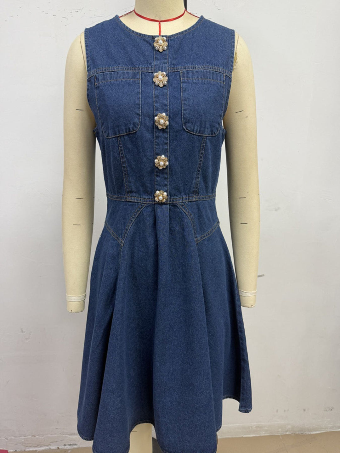 Sleeveless denim mini dress with jeweled buttons