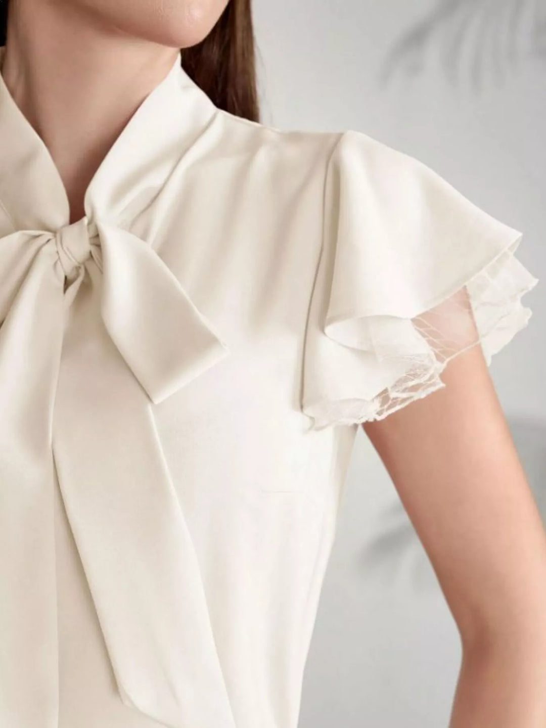 Tie-neck ruffle cap sleeve blouse with lace trim