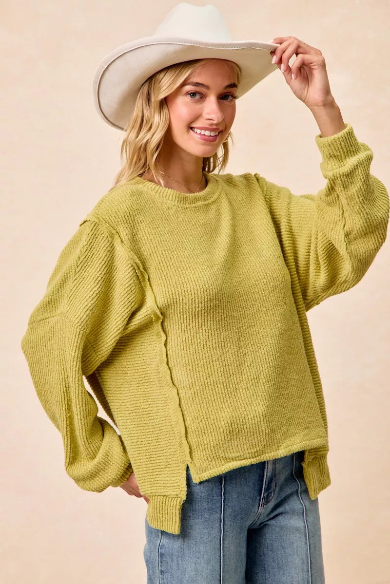 Ribbed boucle knit sweater with exposed seams and uneven hem