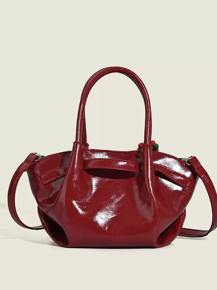 Glossy slouchy top handle crossbody bag with beaded charm