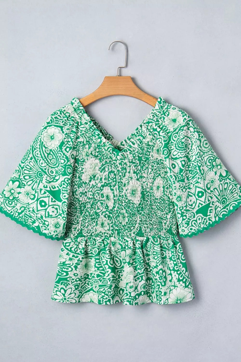 Smocked V-neck floral peplum blouse with flutter sleeves