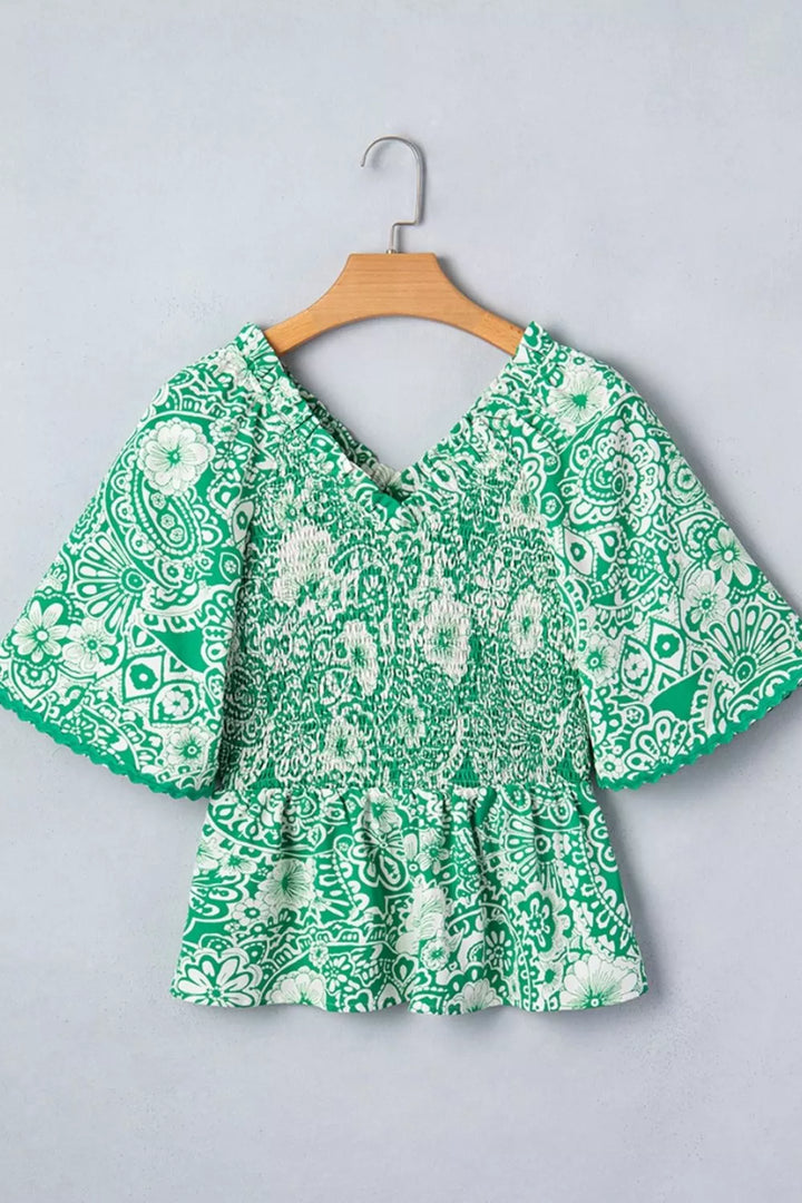Smocked V-neck floral peplum blouse with flutter sleeves