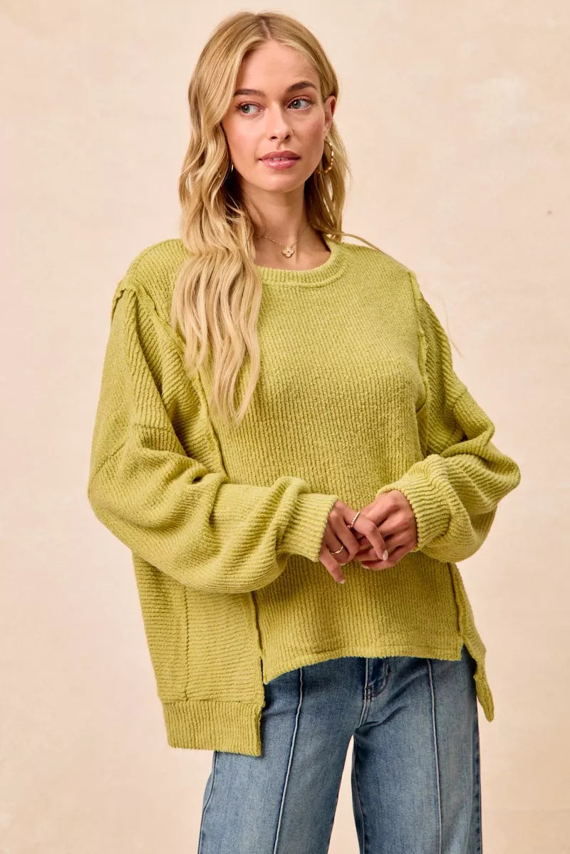 Ribbed boucle knit sweater with exposed seams and uneven hem