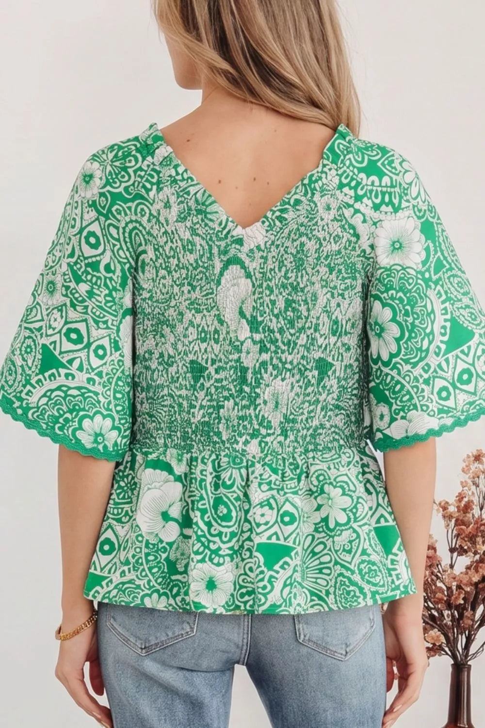 Smocked V-neck floral peplum blouse with flutter sleeves