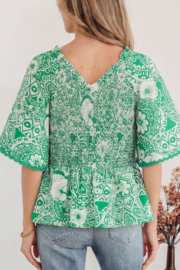 Smocked V-neck floral peplum blouse with flutter sleeves