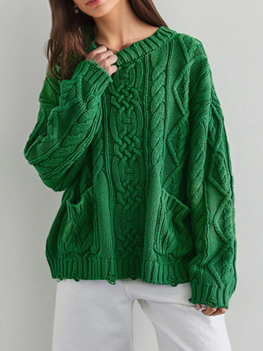 Cable knit sweater with patch pockets and raw hem