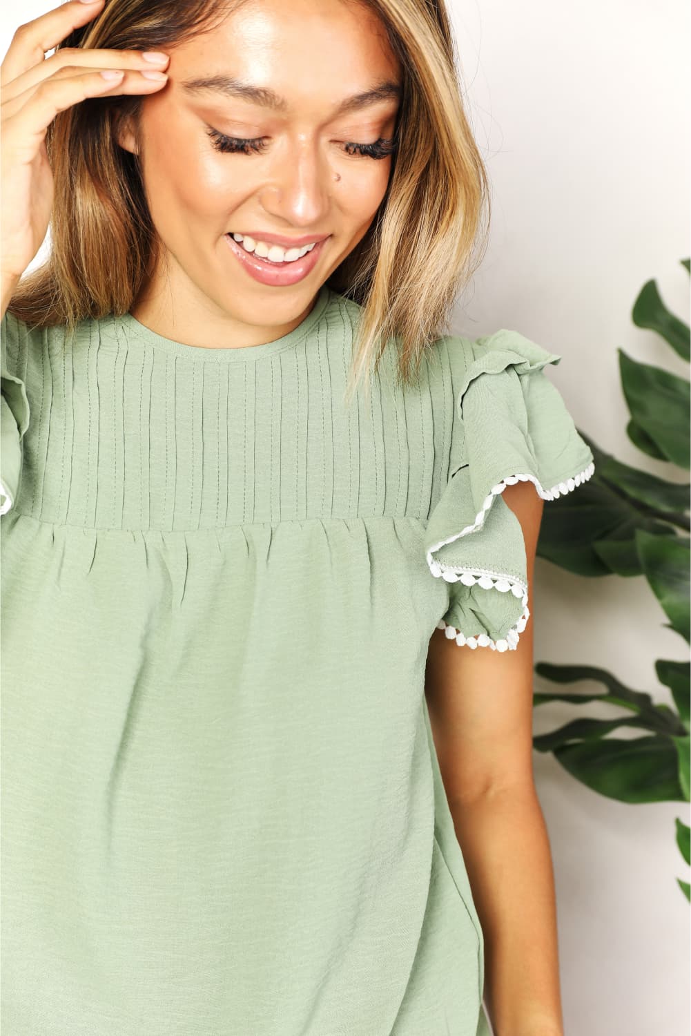 Pintuck yoke flutter sleeve blouse with pom-pom trim