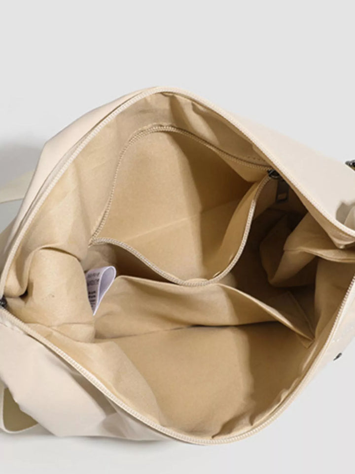 Grommet-studded nylon crossbody sling bag with zip pockets