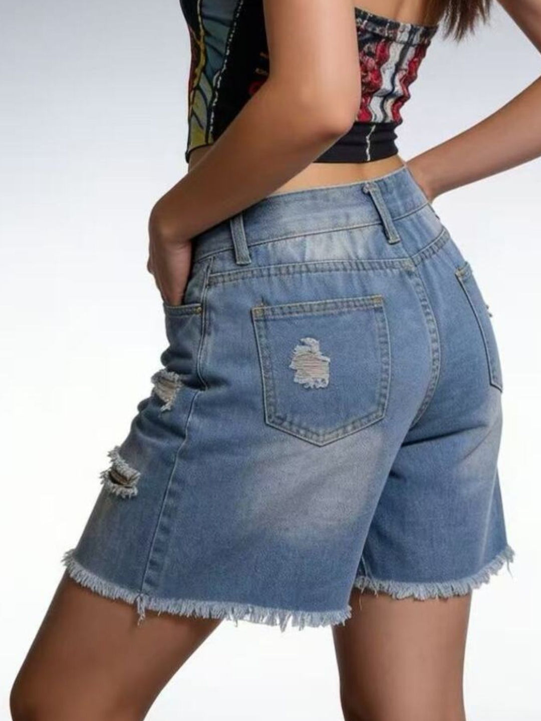Distressed mid-thigh denim shorts with raw frayed hem