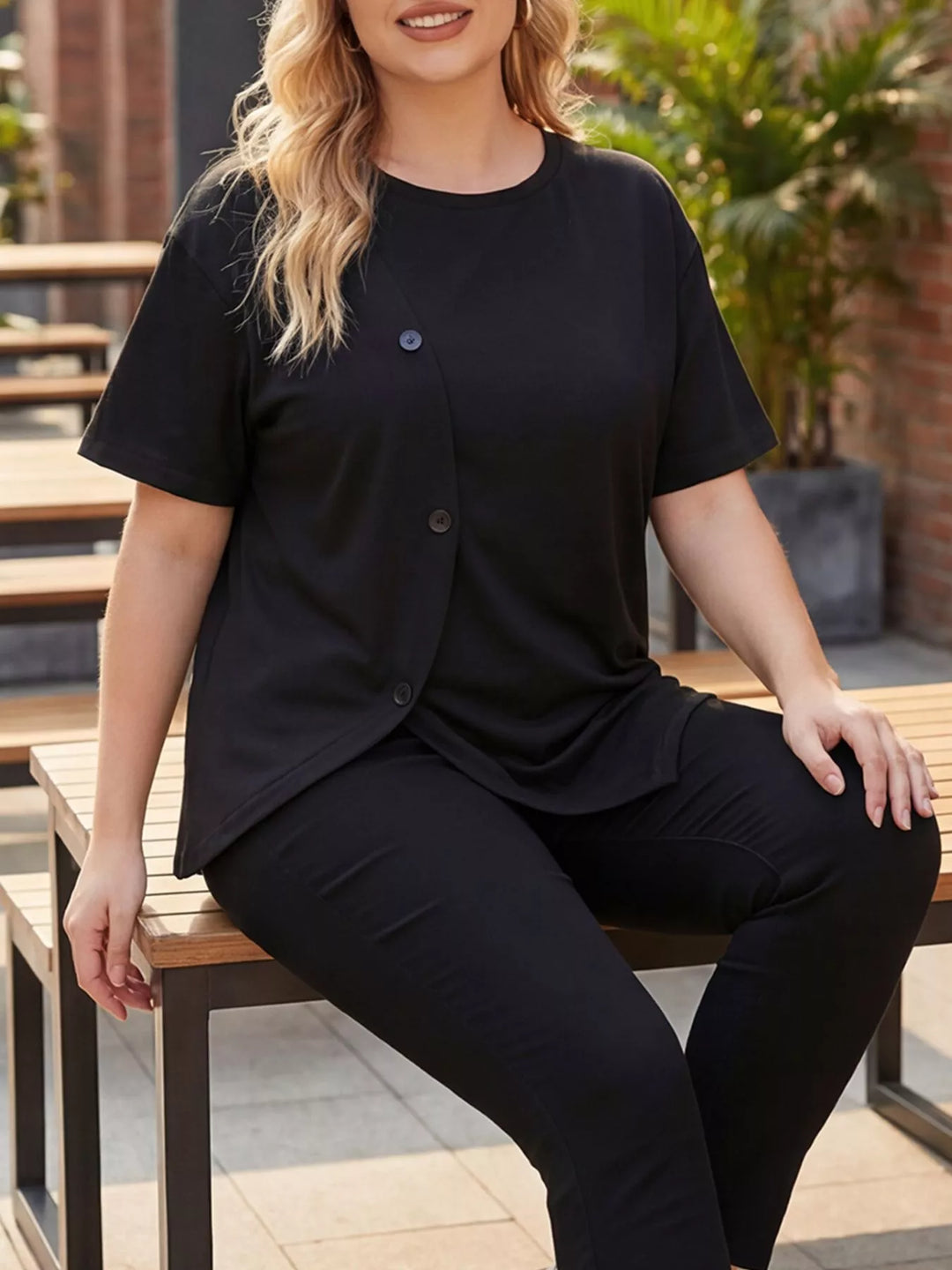 Plus-size short sleeve top with asymmetrical button hem