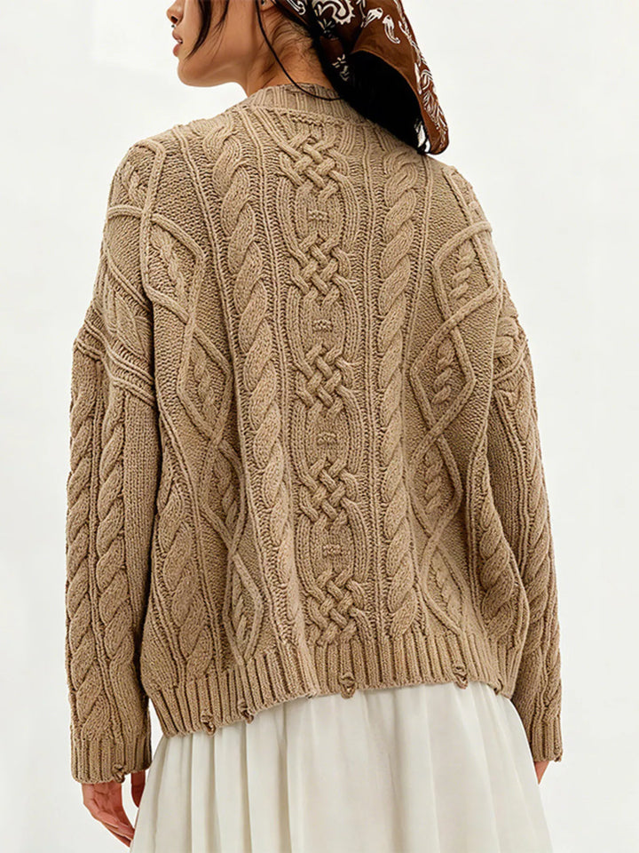 Cable knit sweater with patch pockets and raw hem