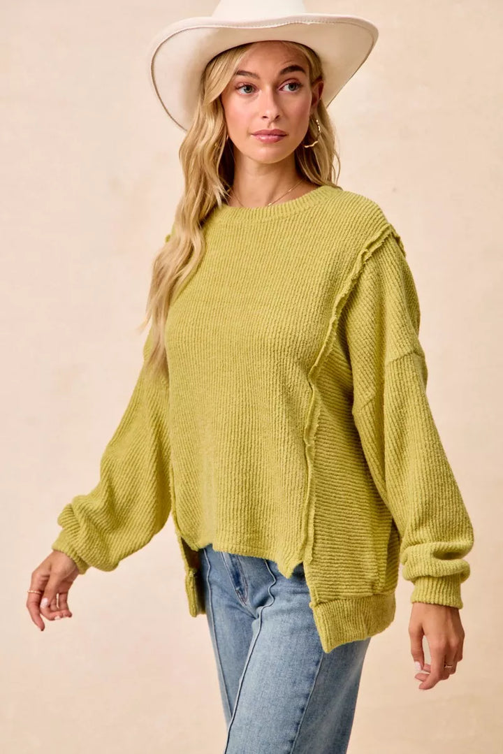 Ribbed boucle knit sweater with exposed seams and uneven hem