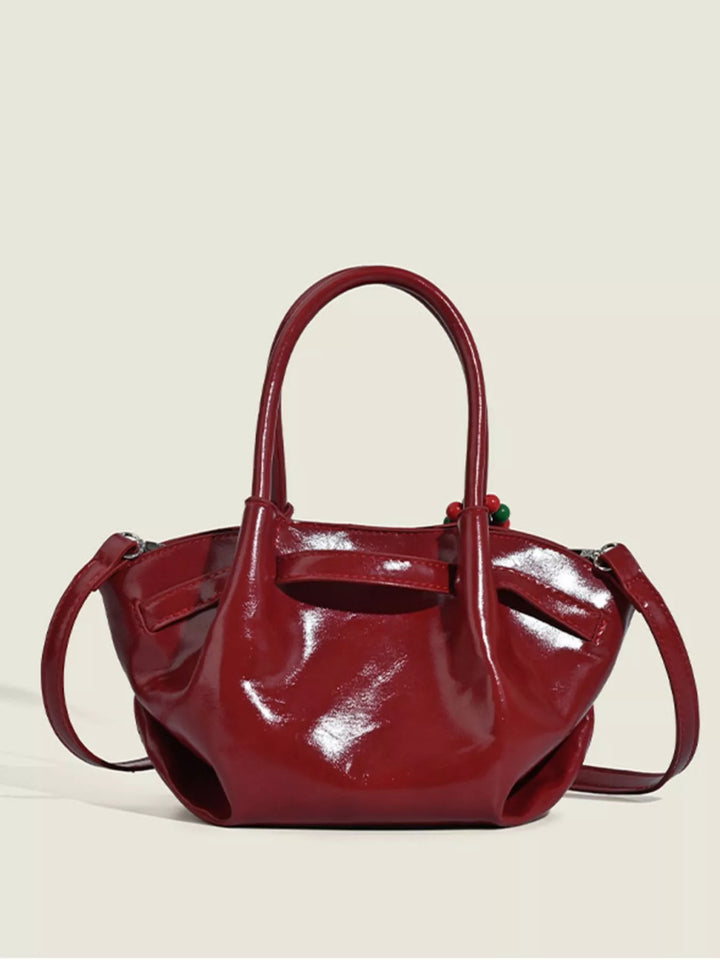 Glossy slouchy top handle crossbody bag with beaded charm