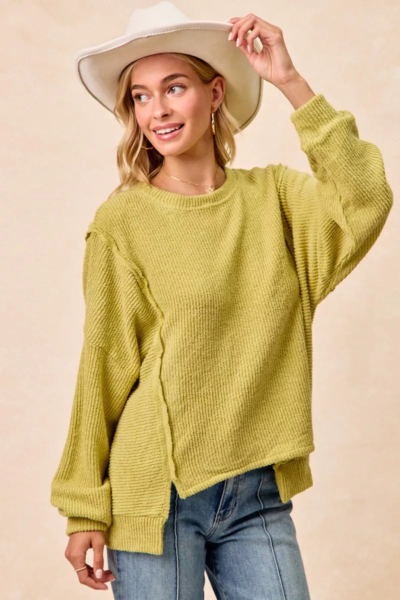Ribbed boucle knit sweater with exposed seams and uneven hem