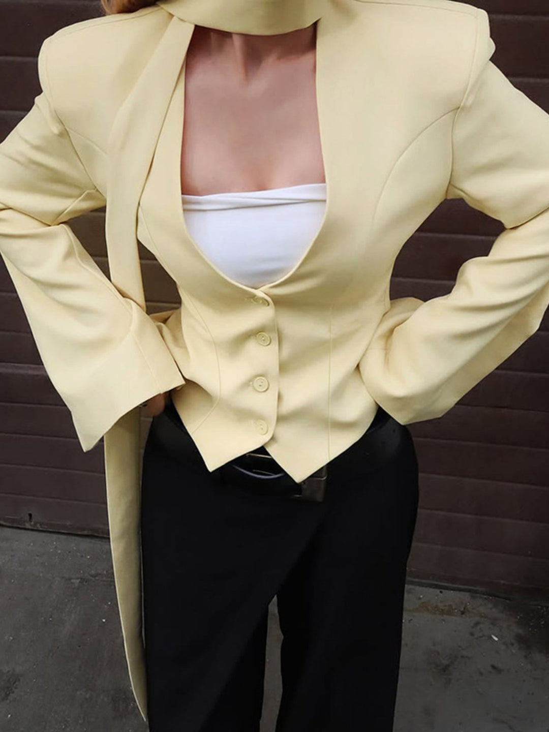 Fitted button-up blazer with tie-neck scarf and structured shoulders