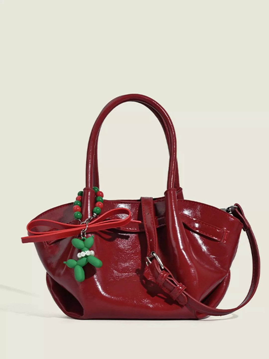 Glossy slouchy top handle crossbody bag with beaded charm
