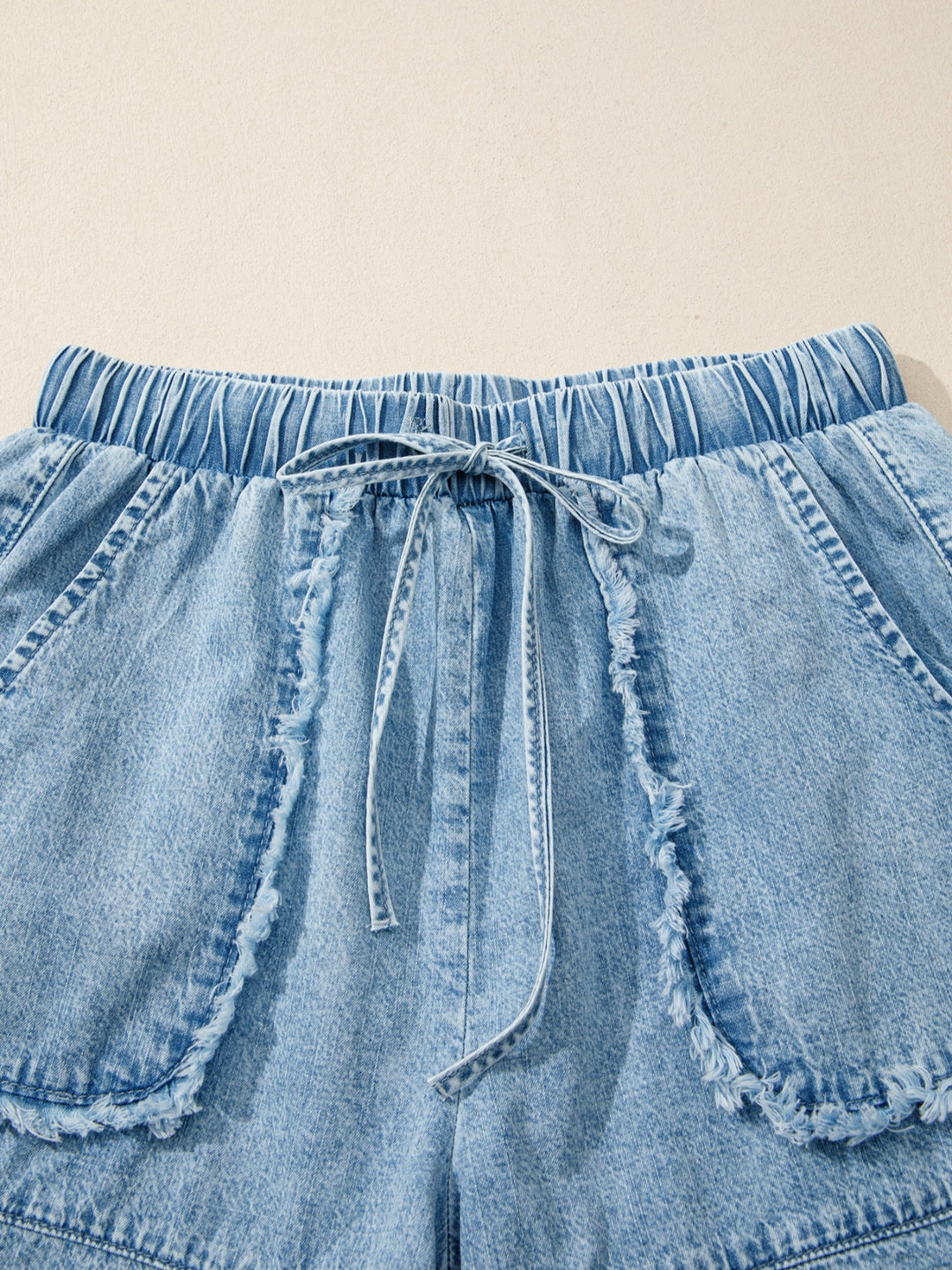 Drawstring denim shorts with raw hem and patch pockets