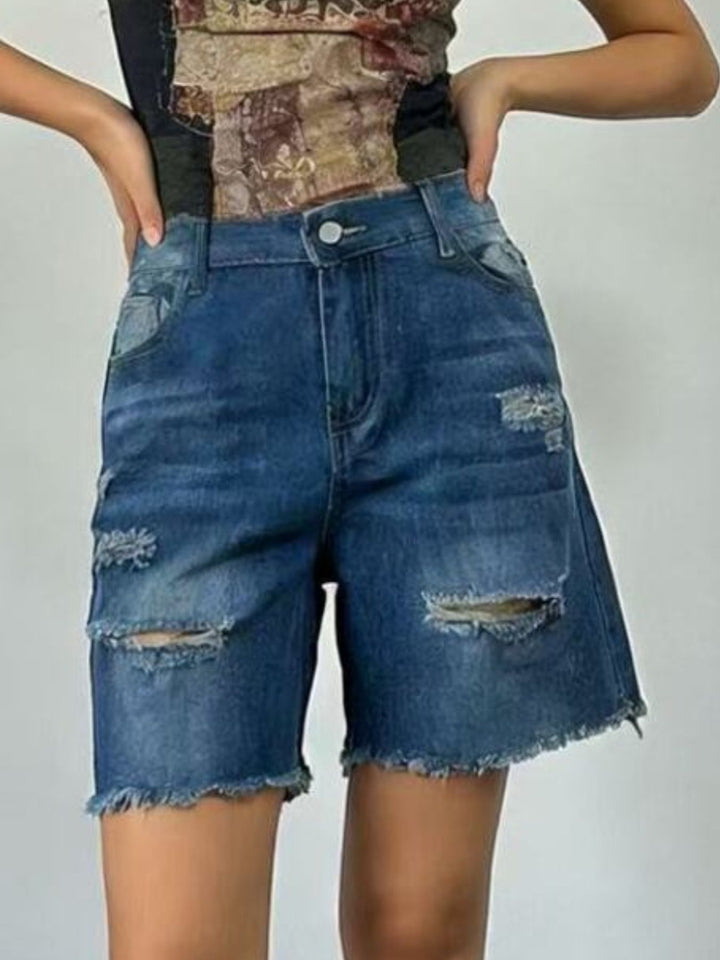 Distressed mid-thigh denim shorts with raw frayed hem