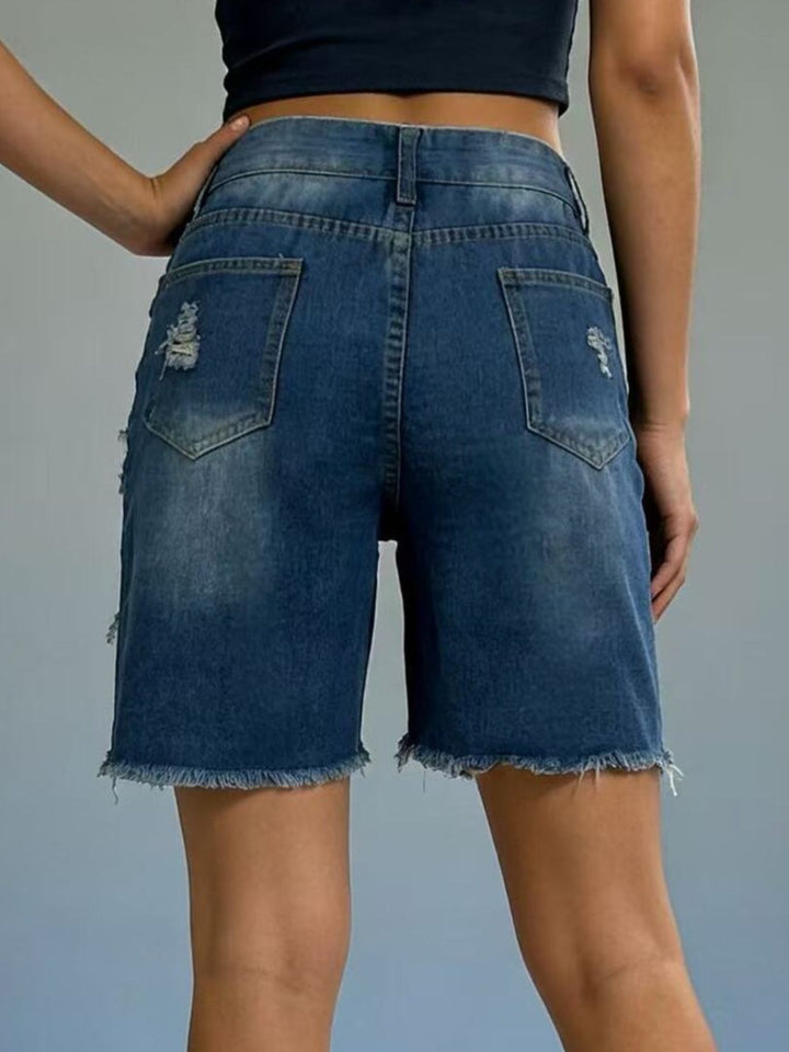 Distressed mid-thigh denim shorts with raw frayed hem
