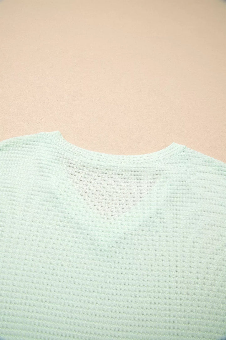 Plus size waffle knit V-neck top with cuffed short sleeves