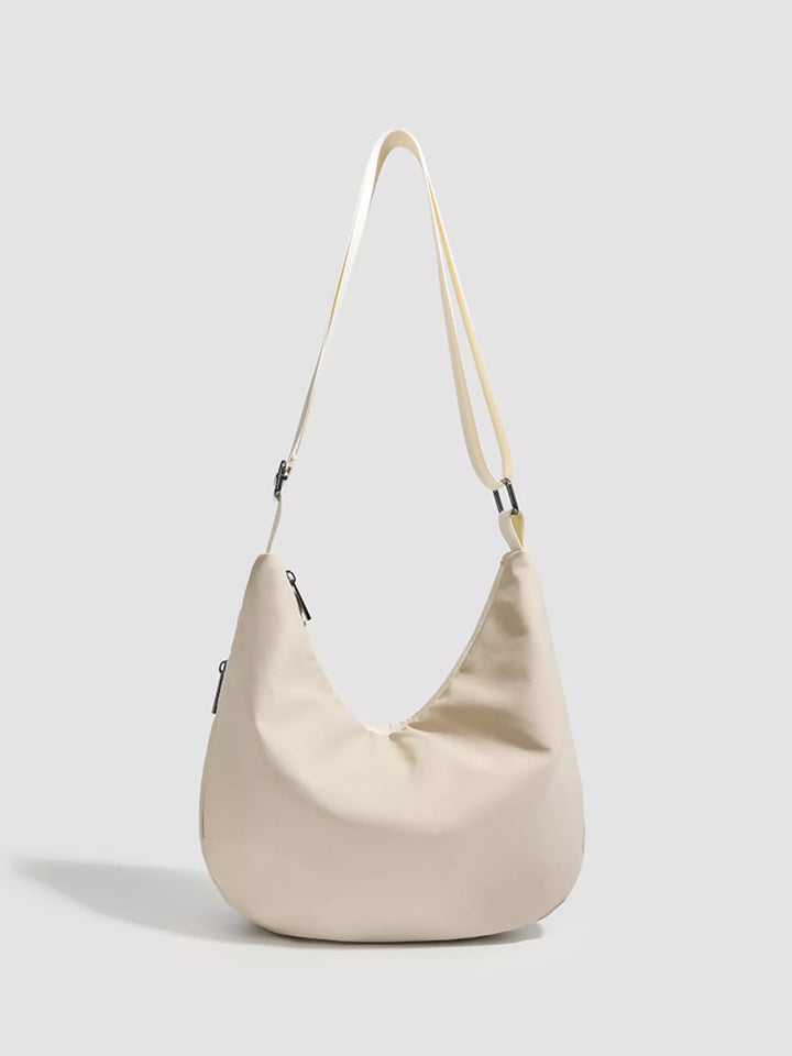 Grommet-studded nylon crossbody sling bag with zip pockets