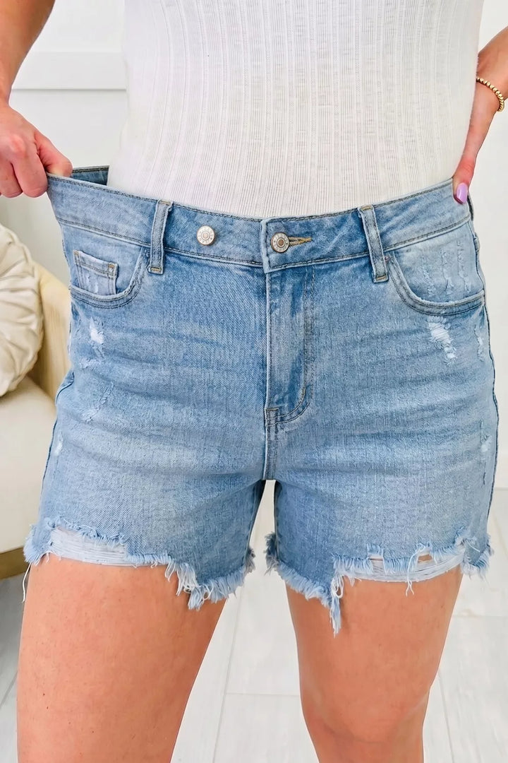 Medium Distressed mid-rise denim shorts with asymmetric raw hem