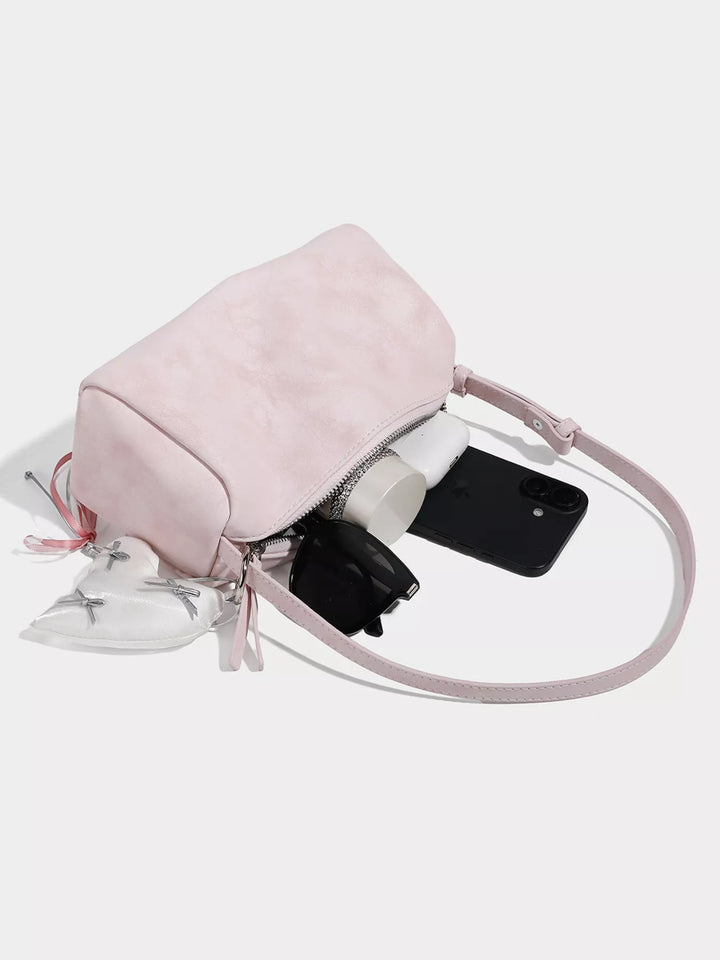 Adjustable strap crossbody bag with heart charm and bow trim