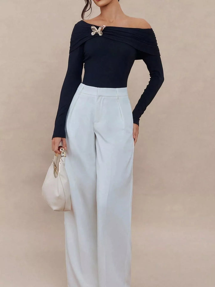 Off-shoulder long sleeve top with gold butterfly brooch