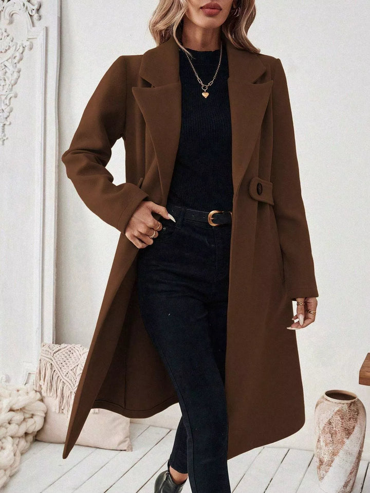 Longline notch lapel coat with single-button waist tab