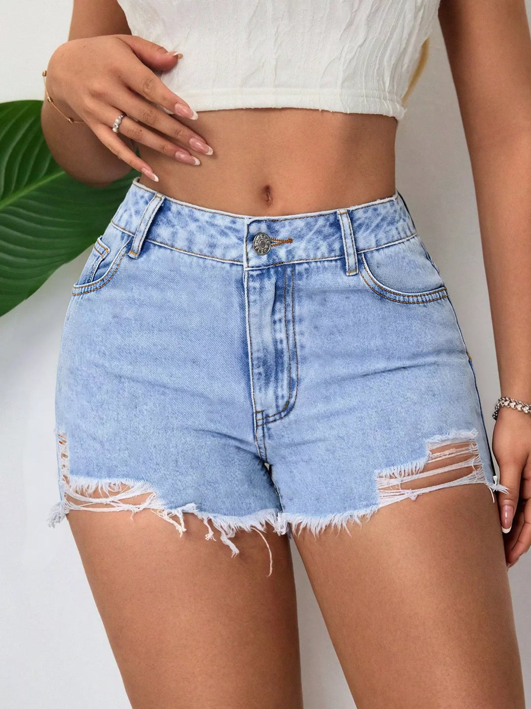 High-rise distressed denim shorts with raw hem