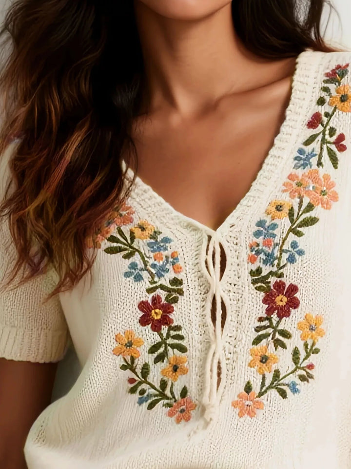 Floral embroidered short sleeve knit sweater with lace-up neckline